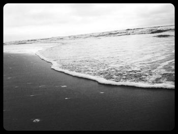 Scenic view of beach against cloudy sky