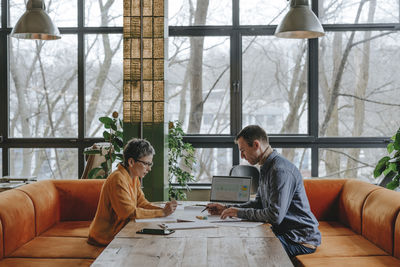 Businessman discussing over project with colleague in office