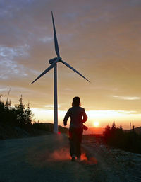 Silhouette man standing on field against sky during sunset