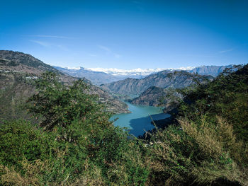 Scenic view of lake and mountains against blue sky