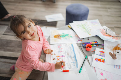High angle view of girl drawing on book