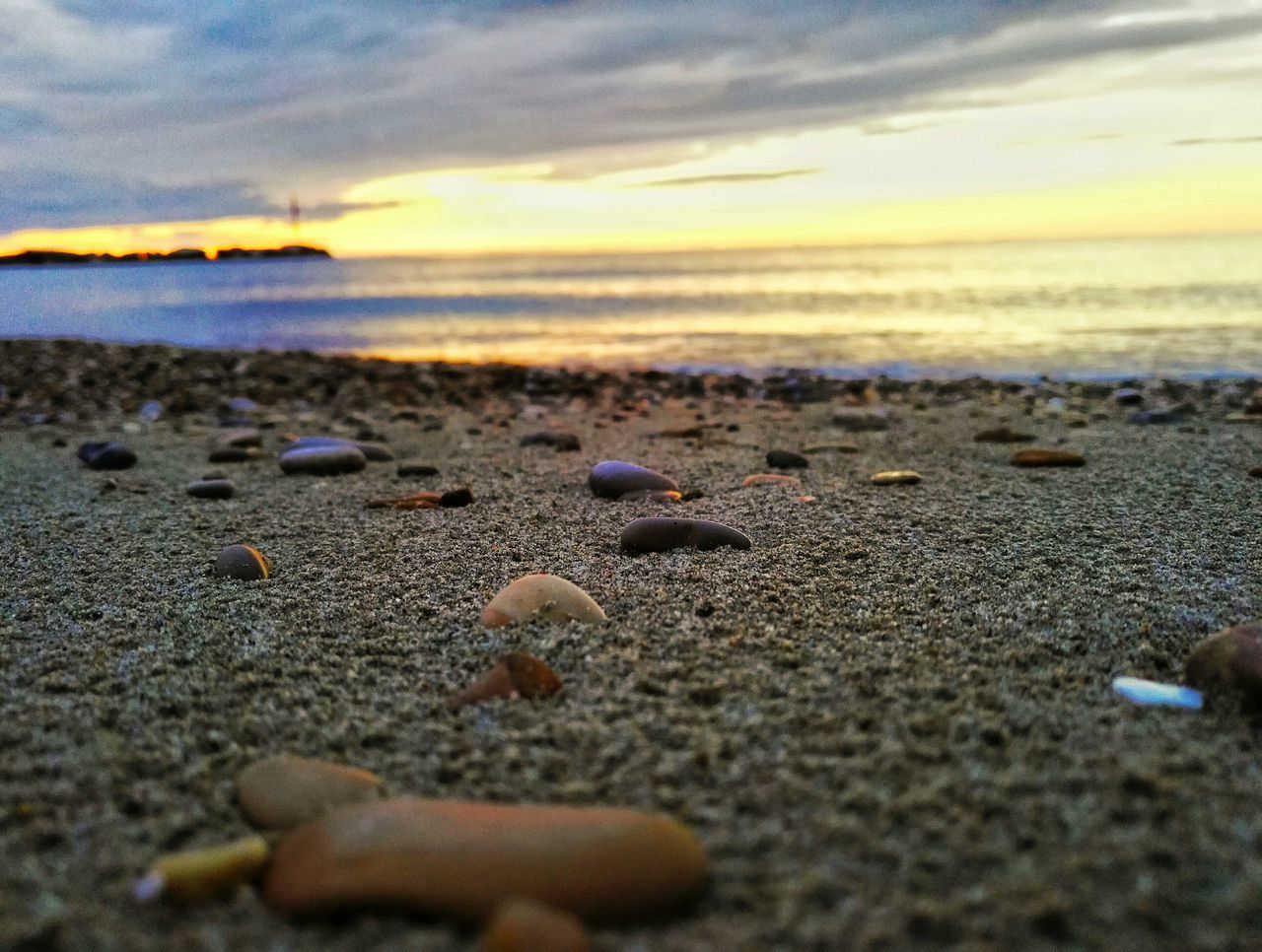 beach, sea, sand, shore, water, tranquility, horizon over water, nature, beauty in nature, sky, surface level, scenics, tranquil scene, pebble, sunset, idyllic, cloud - sky, coastline, stone - object, outdoors