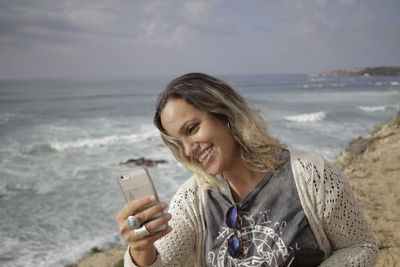Woman using mobile phone at beach