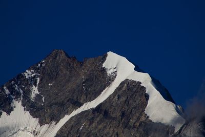Scenic view of snowcapped mountains against clear blue sky