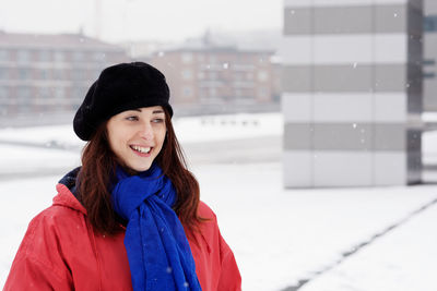 Smiling young woman at city in winter