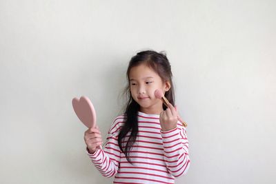 Cute girl standing against wall
