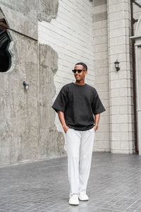 Portrait of young man standing against wall