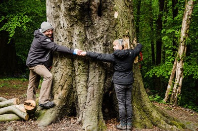 Man standing on tree trunk in forest