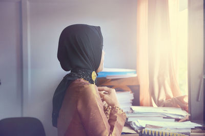 Rear view of woman working at home