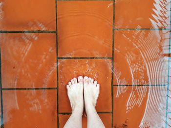 Low section of woman standing on wet floor