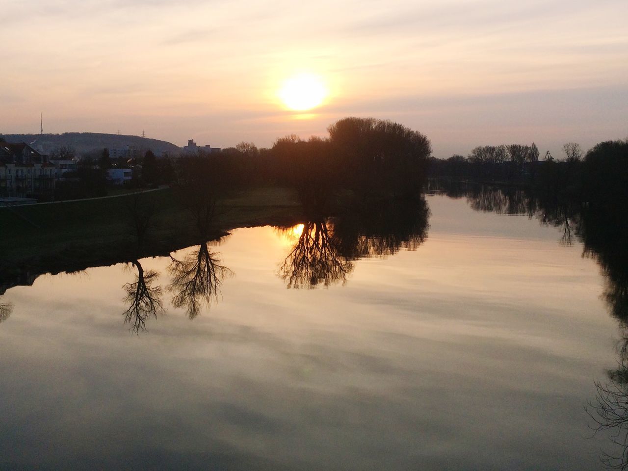 sunset, reflection, water, tranquil scene, sky, tranquility, scenics, lake, tree, beauty in nature, sun, silhouette, orange color, nature, cloud - sky, idyllic, waterfront, river, sunlight, standing water