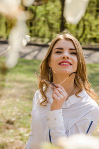 Portrait of a smiling young woman holding plant