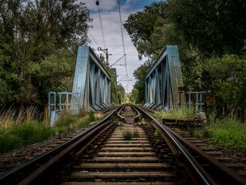 Railroad tracks by trees against sky