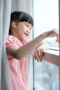 Cute girl looking away while standing at home