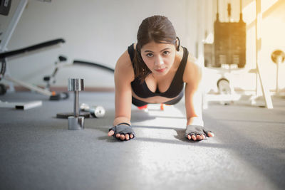 Portrait of young woman exercising at gym