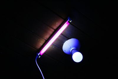 Low angle view of illuminated light bulbs in the dark