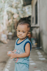 Portrait of cute baby girl holding footpath
