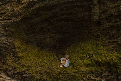 Rear view of couple sitting on land