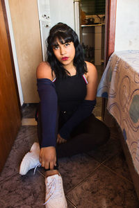 Portrait of woman sitting on floor at home