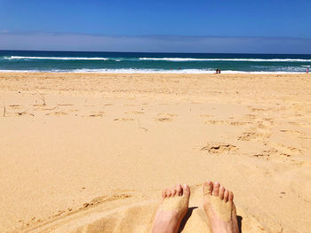 Low section of people relaxing on beach