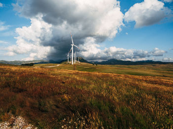 Windmill on field against sky