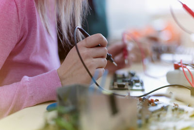 Midsection of woman using electronic equipment