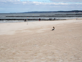 Woman at sandy beach against sky