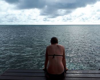 Rear view of woman looking at sea against sky