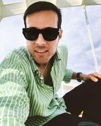 Portrait of young man wearing sunglasses sitting outdoors