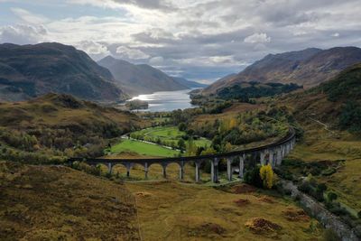 Scenic view of bridge over mountains against sky