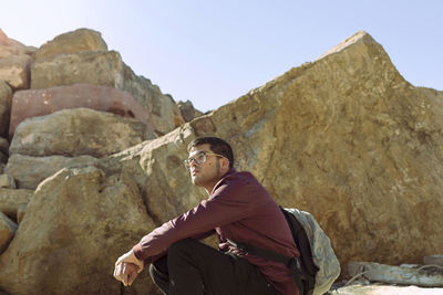 Low angle view of woman standing on mountain against clear sky