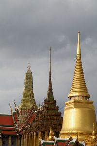 Low angle view of wat phra kaew against cloudy sky