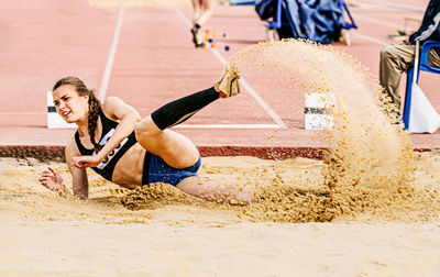 Female athlete falling on dirt