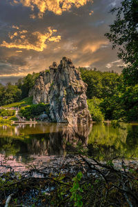 Scenic view of rock by lake against sky