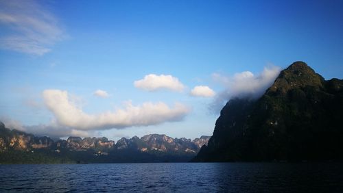 Scenic view of lake and mountains against blue sky