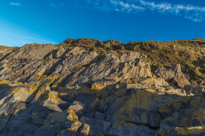 Scenic view of rocky cliffs against blue sky