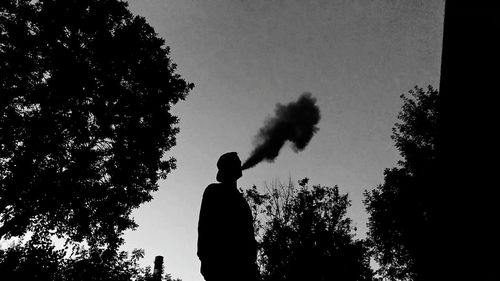 Low angle view of silhouette man standing against clear sky