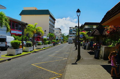 People walking on road along buildings