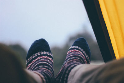 Low section of person wearing socks in tent