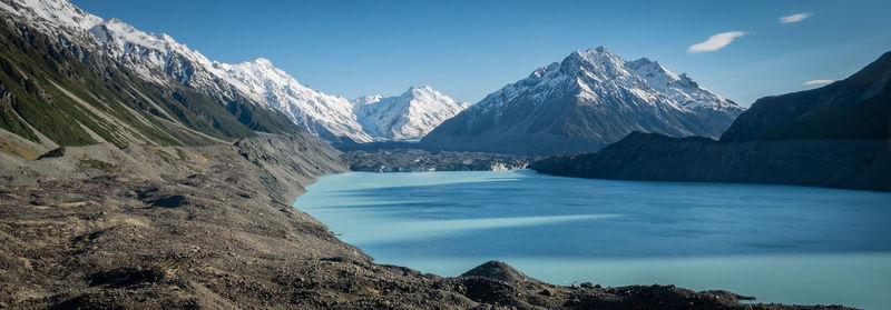 Panoramic shot of blue glacial lake and glacier with mountains in backdrop.mt cook np, new zealand