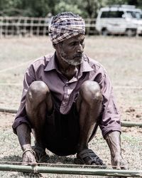 Man looking away while sitting outdoors