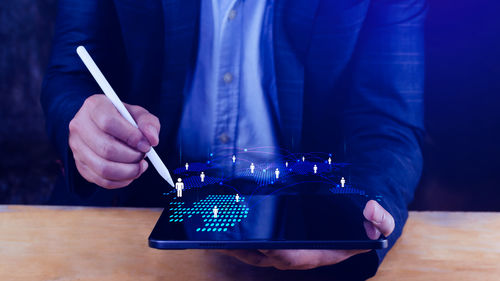 Midsection of man using mobile phone