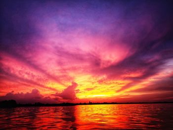 Scenic view of sea against dramatic sky during sunset