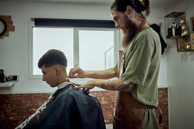 A hairdresser working with a knife on a client