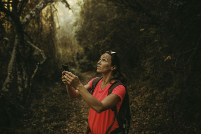 Young woman using mobile phone while standing on land