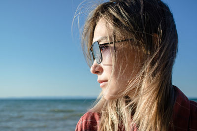 Portrait of woman at beach against sky