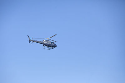 Low angle view of airplane against clear blue sky