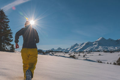 An unrecognizable young caucasian woman running towards the french alps mountains