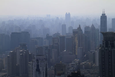 Aerial view of buildings in city against sky