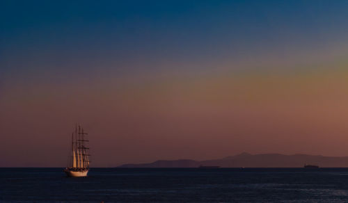 Sailboat sailing on sea against sky during sunset